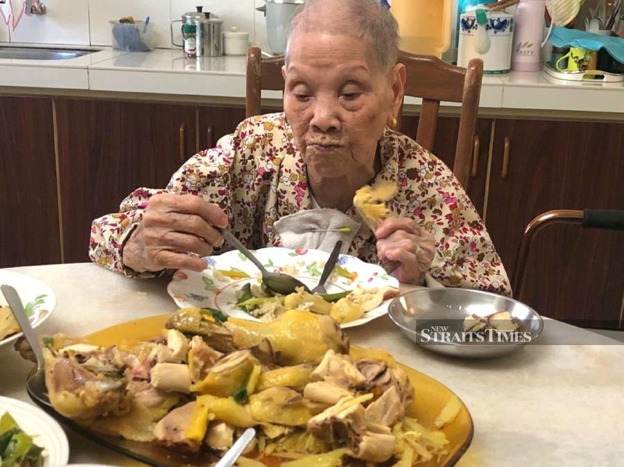  The writer's mother enjoying her Chinese New Year meal of castrated chicken in 2017.