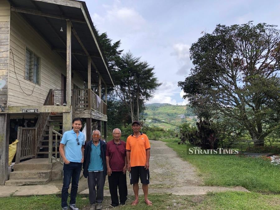  The writer (far left) with (from left) Pak Ladasu, Kusop Gorihim and Sokuil, standing next to Pak Ladasu's wooden house.