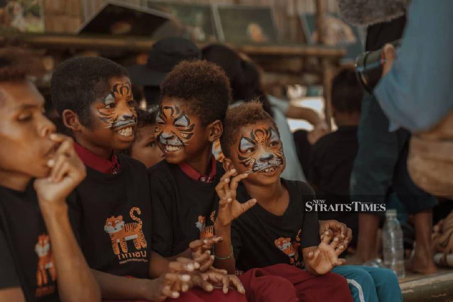 Orang asli children with their faces masked in tiger stripes at the Royal Belum Forest in Perak.