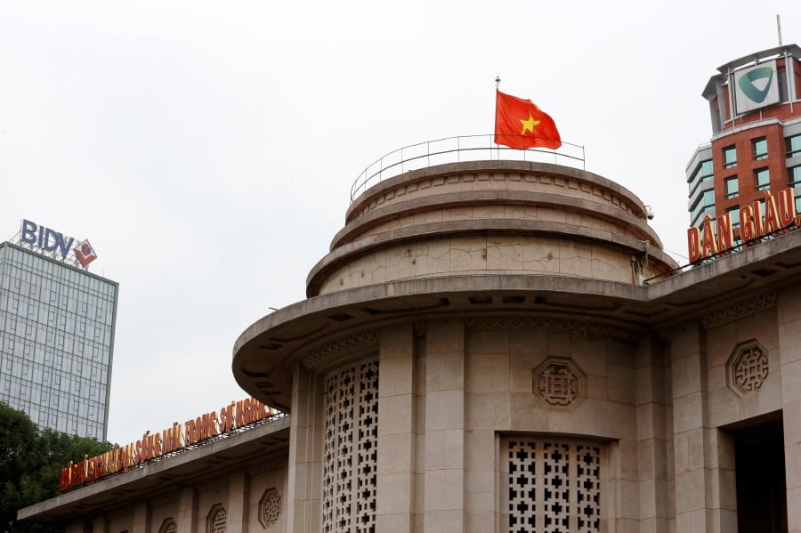 A Vietnamese flag flies atop the State Bank building, near the Vietcombank and Bank for Investment and Development of Vietnam buildings, in central Hanoi, Vietnam. REUTERS/Kham/File Photo