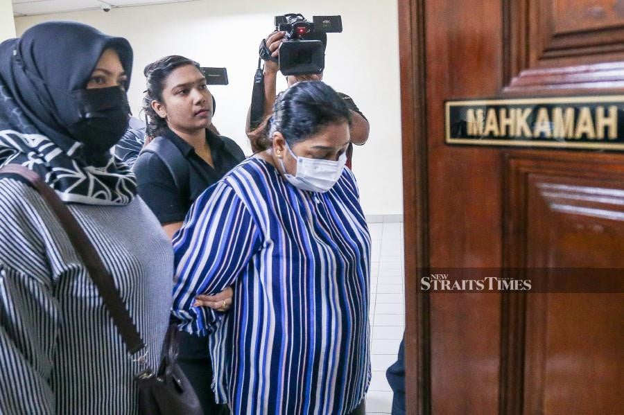  M Vijairani is escorted by police officers at the Butterworth Session’s Court ahead of the trial. -NSTP/DANIAL SAAD