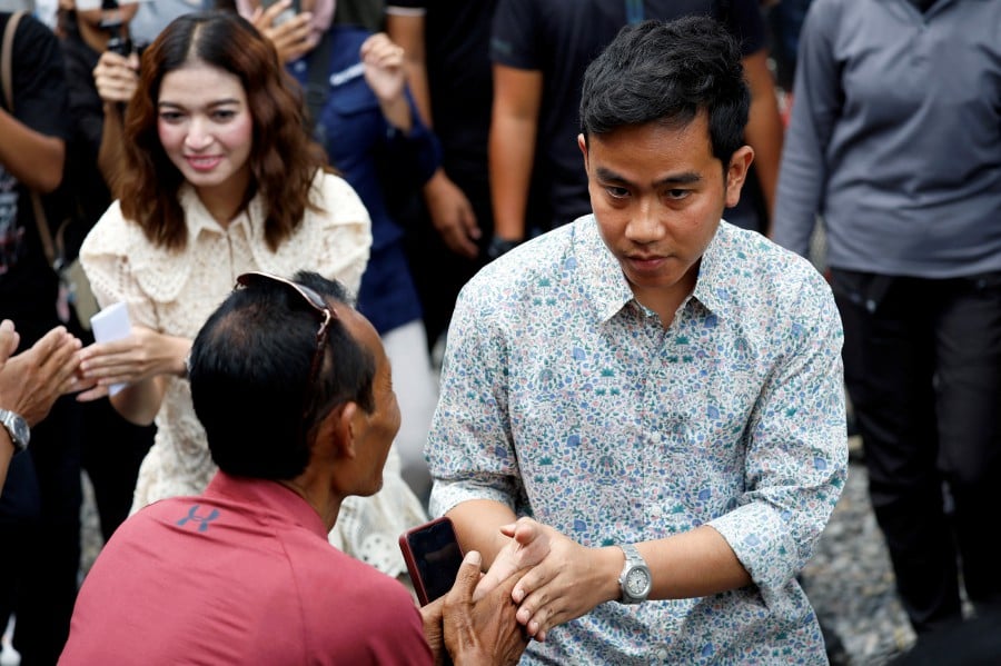Vice President candidate Gibran Rakabuming Raka, who is the eldest son of Indonesian President Joko Widodo and current Mayor of Surakarta, along with his wife Selvi Ananda, greet his supporters as they arrive at a polling station to vote during the general election, in Surakarta, Central Java province, Indonesia. - REUTERS PIC
