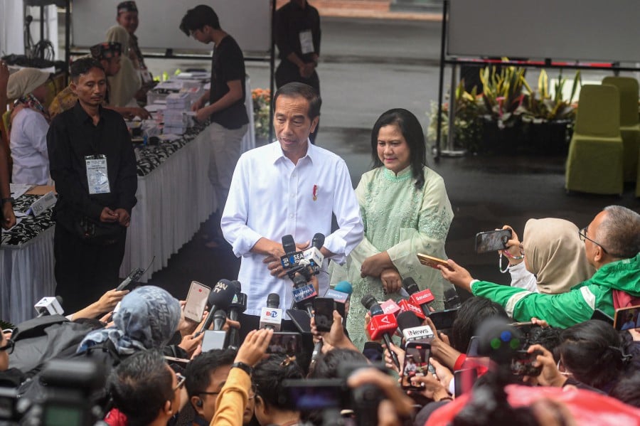 President Joko Widodo and First Lady Iriana speak to the media after casting their ballots at a polling station during general election in Jakarta, Indonesia. - REUTERS PIC
