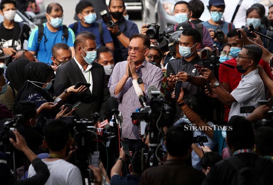  PKR president Datuk Seri Anwar Ibrahim (centre) gestures while speaking to press in front of  Bukit Aman in Kuala Lumpur. -NSTP/MOHAMAD SHAHRIL BADRI SAALI