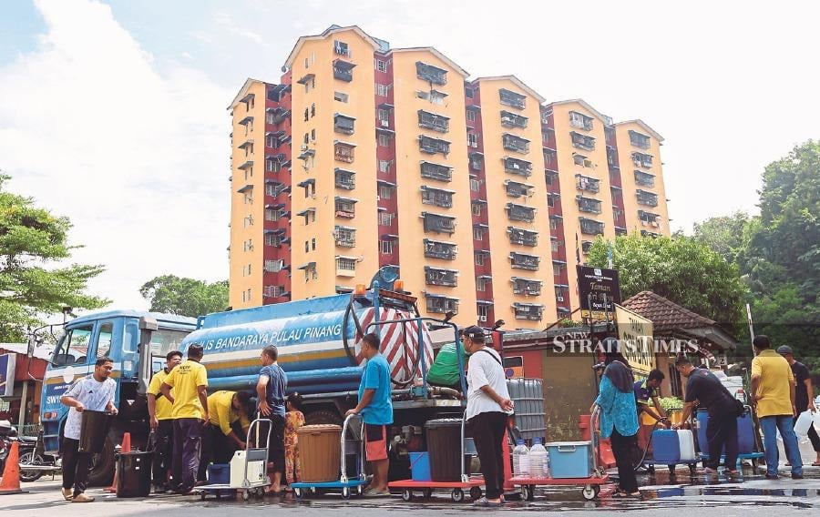 Residents getting water from Penang City Council tankers in Taman Sri Bayu, Bayan Lepas recently. More than 120,000 consumers had their water supply cut after a pipe burst in Sungai Prai, Butterworth, recently. - FILE PIC