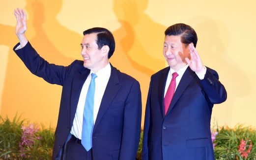 Chinese President Xi Jinping (R) and Taiwan President Ma Ying-jeou wave to journalists before their meeting at Shangrila hotel in Singapore. AFP