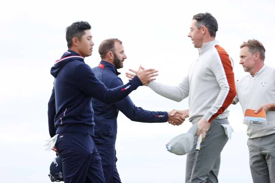  Collin Morikawa and Dustin Johnson of team United States shake hands with Rory McIlroy of Northern Ireland and Ian Poulter of England and team Europe after defeating them 4&3 during Saturday Afternoon Fourball Matches of the 43rd Ryder Cup at Whistling Straits on September 25, 2021 in Kohler, Wisconsin. - AFP PIC