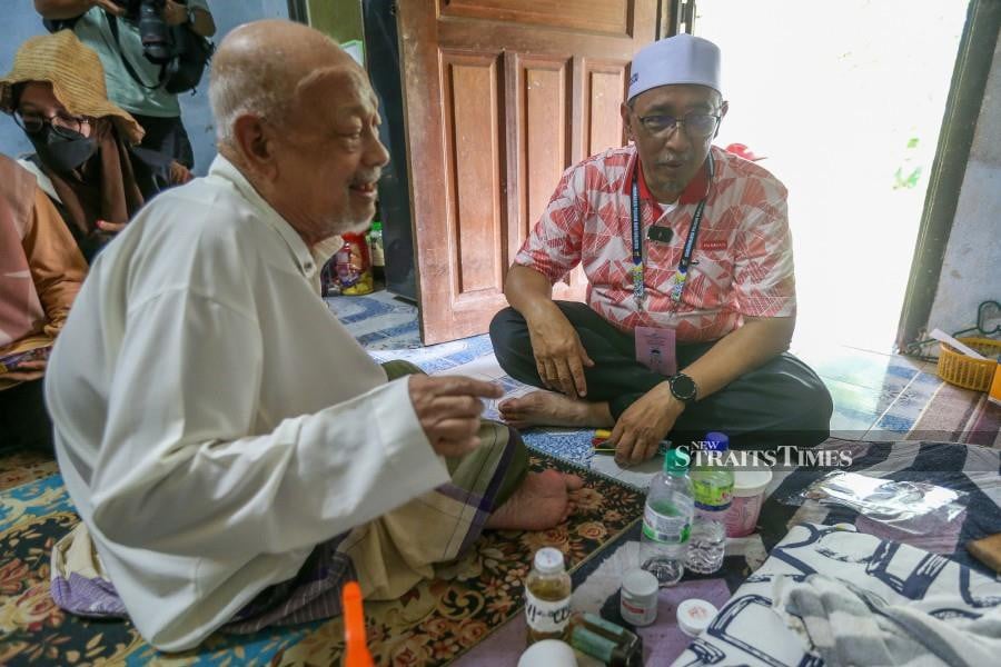 Dr Joohari Ariffin (right) speaking to Che Dan Razak in Kampung Sungai Buaya. -NSTP/DANIAL SAAD