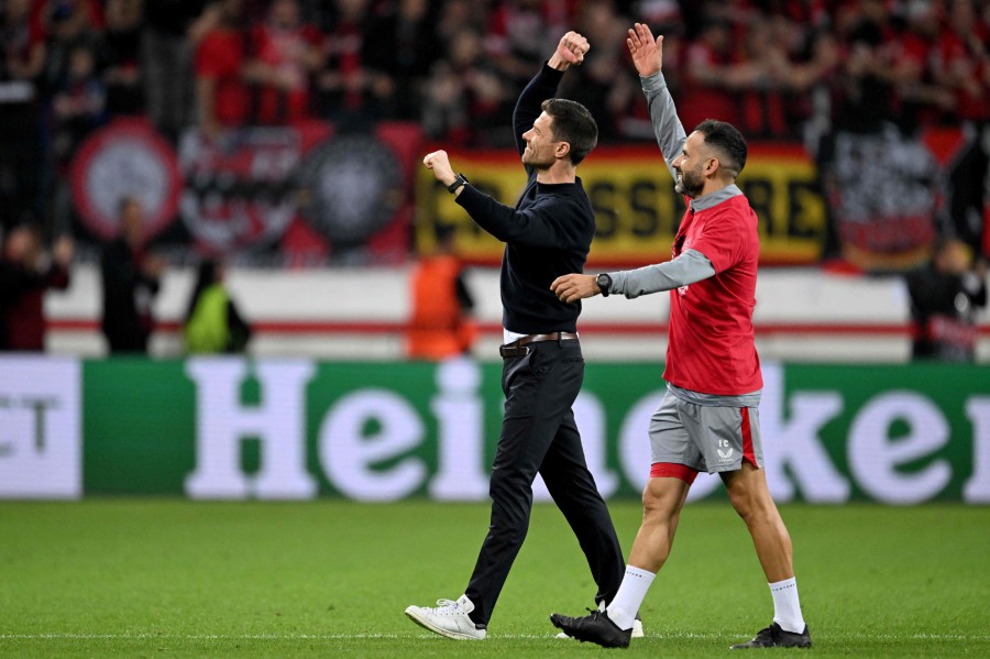 Bayer Leverkusen's Spanish head coach Xabi Alonso (L) and Leverkusen's fitness coach Ismael Camenforte Lopez celebrate after the UEFA Europa League semi final second leg football match against AS Roma in Leverkusen. - AFP PIC