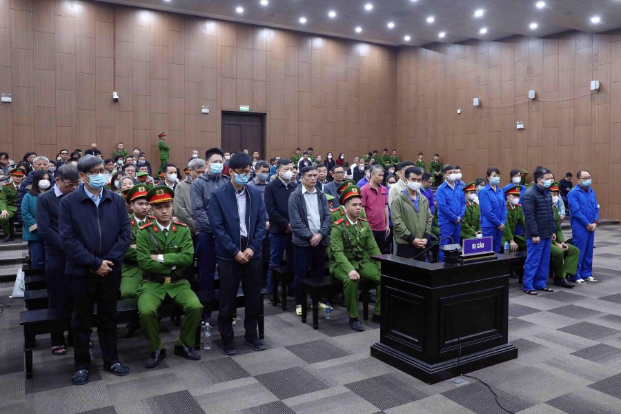 Defendants standing during their anti-corruption trial over Covid test kit production bribes in Hanoi.-AFP PIC