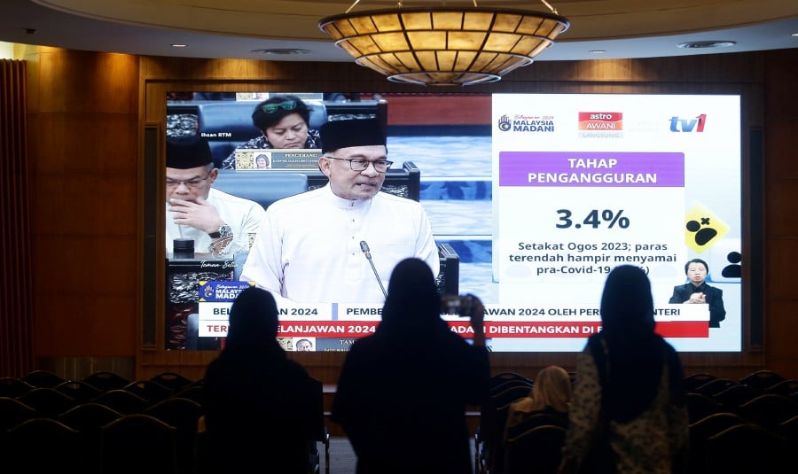 Civil servants tune in to the 2024 Budget live telecast on a large screen in Putrajaya on Oct 13. -NSTP/MOHD FADLI HAMZAH