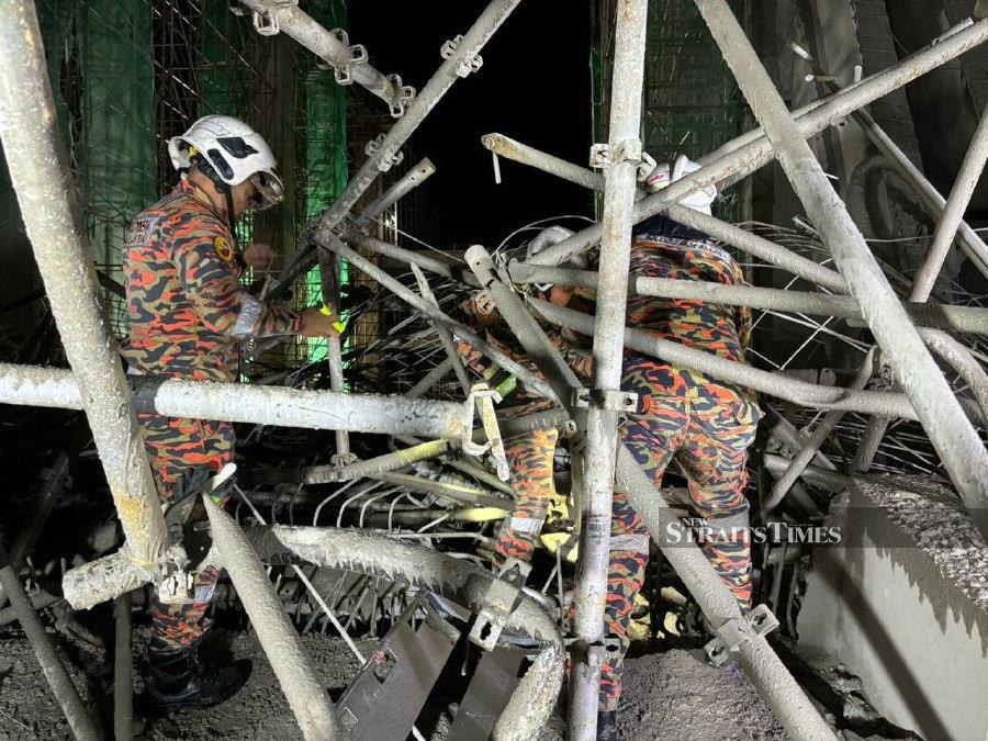 Rescuers on the scene following the collapsed structure of a ware house in Batu Maung. - Pic courtesy of Fire and Rescue Dept.