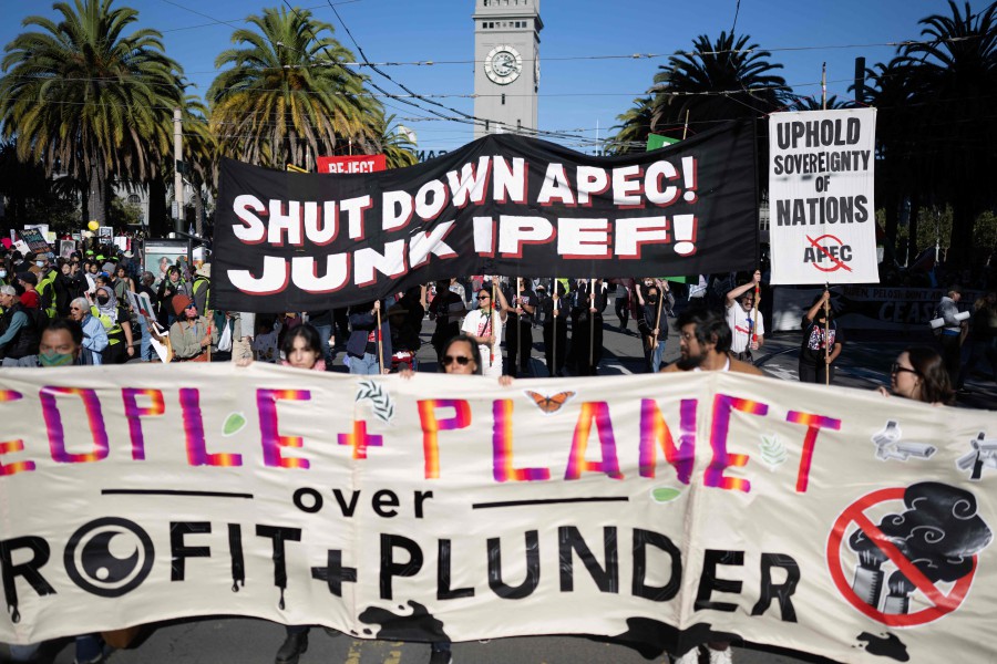 Demonstrators hold placards during the "No on APEC" protest on the sidelines of the Asia-Pacific Economic Cooperation (APEC) Leaders' Meeting in San Francisco, California. - AFP PIC