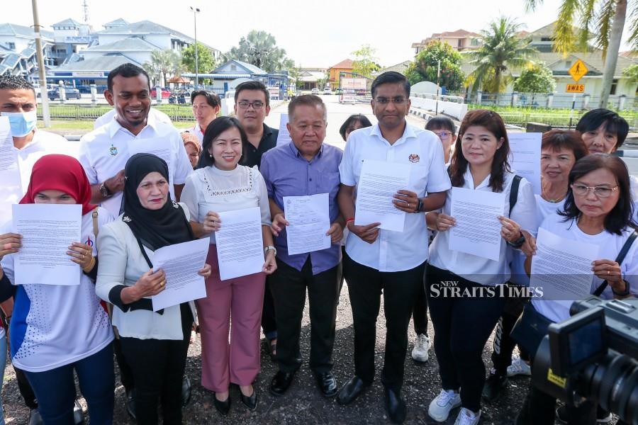  National DAP Veterans Club chairman Lay Hock Peng (5th-right) showing a copy of the police report lodged at the Seberang Perai Utara district police headquarters. -NSTP/DANIAL SAAD