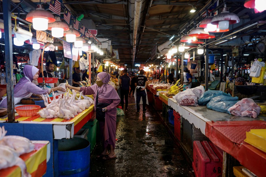 A woman is seen purchasing daily good at the Chow Kit wet market in Kuala Lumpur recently. - BERNAMA PIC