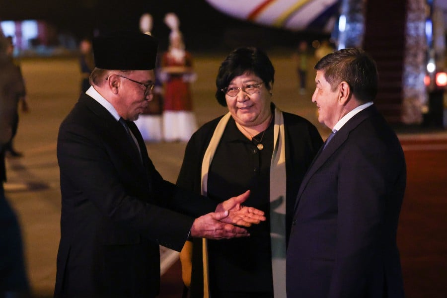 Prime Minister Datuk Seri Anwar Ibrahim (left) is greeted by his counterpart, Chairman of the Cabinet of Ministers of the Kyrgyz Republic Akylbek Zhaparov (right) at Manas International Airport, Bishkek. - BERNAMA PIC