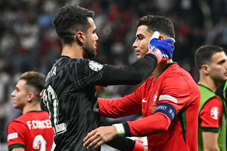 Portugal's goalkeeper Diogo Costa and forward Cristiano Ronaldo celebrate their win at the end of the UEFA Euro 2024 round of 16 football match between Portugal and Slovenia at the Frankfurt Arena in Frankfurt. - AFP PIC