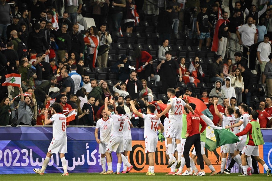 Tajikistan's players celebrate their win after the Qatar 2023 AFC Asian Cup Group A football match between Tajikistan and Lebanon at the Jassim bin Hamad Stadium in Doha. - AFP PIC
