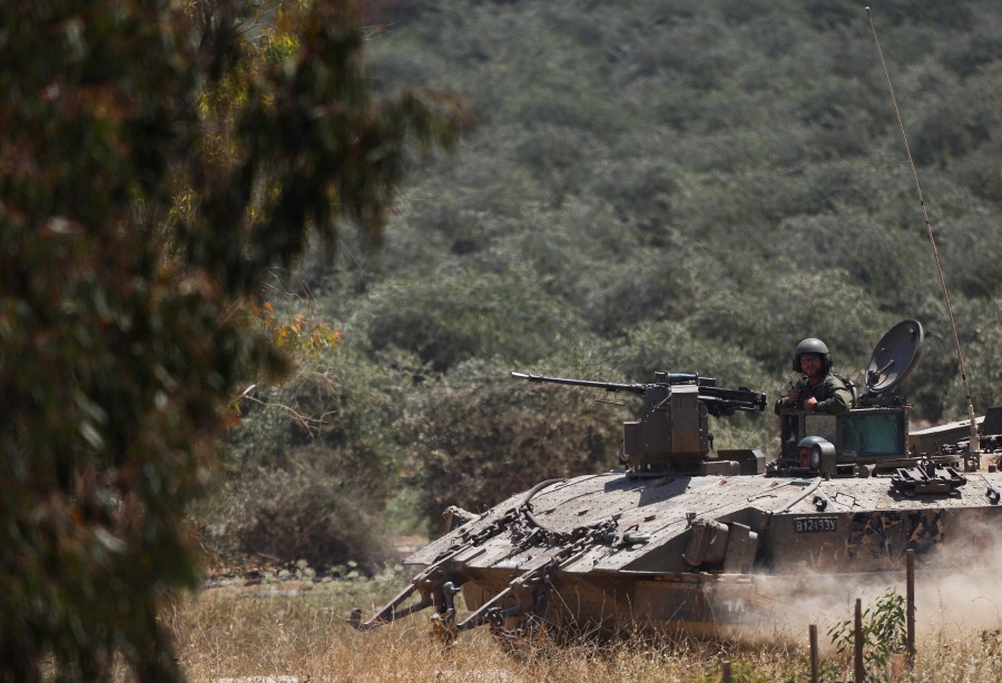 Israeli soldiers sit in a military vehicle near Israel's border with Gaza. -REUTERS PIC