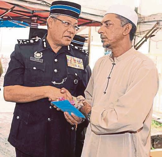Datuk Wira Ayub Yaakub presents an undisclosed amount from the PDRM Welfare Fund to Abdullah Mahmood.