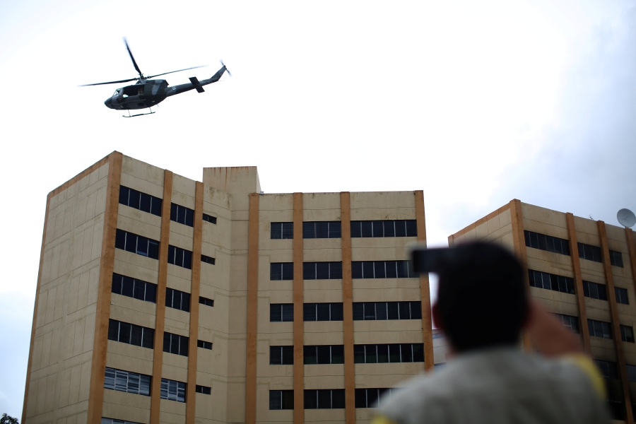 A Salvadoran army helicopter flies over the ministry of treasury building during a blaze in San Salvador, El Salvador. REUTERS