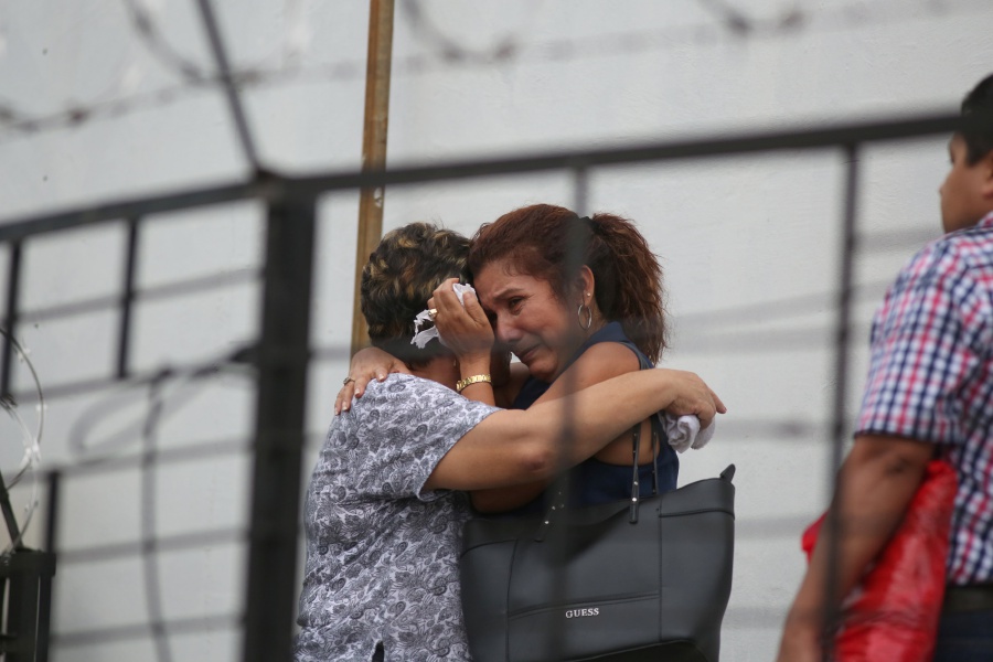 Workers react as they learn their co-worker died in the San Salvador fire. REUTERS