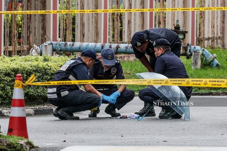 Police officers inspecting the package left in front of the Kuala Terengganu court complex. -NSTP/GHAZALI KORI