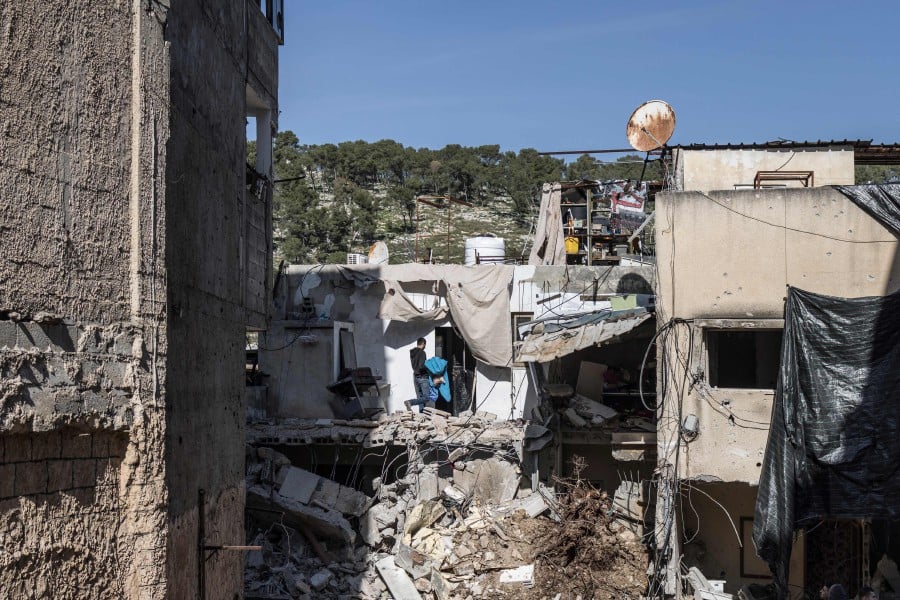 A man salvages his belongings as he walks into his damaged house in the Palestinian Nur Shams refugee camp in Tulkarem, on January 18, 2024, after an Israeli army operation. - AFP PIC