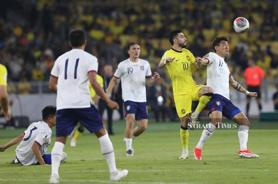 Malaysia’s Endrick Dos Santos (centre) and Taiwan’s Chen Po Liang (right) vie for the ball during the match at the National Stadium, Bukit Jalil. -NSTP/MOHAMAD SHAHRIL BADRI SAALI
