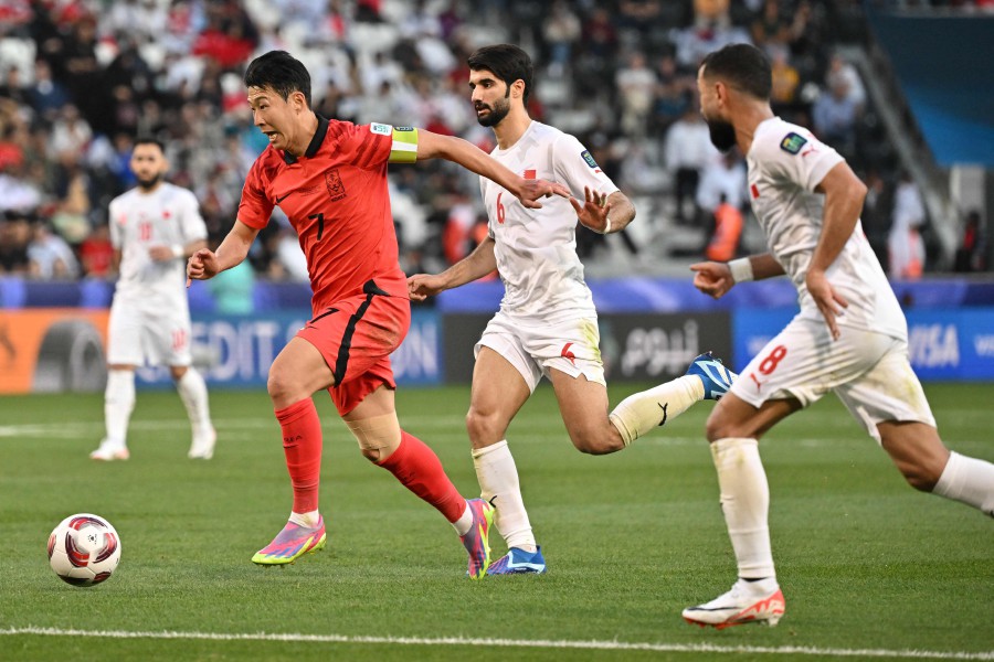 South Korea's midfielder Son Heung-min runs with the ball past Bahrain's midfielders Mohamed Marhoon and #06 Mohamed al-Hardan during the Qatar 2023 AFC Asian Cup Group E football match between South Korea and Bahrain at the Jassim bin Hamad Stadium in Doha. - AFP PIC
