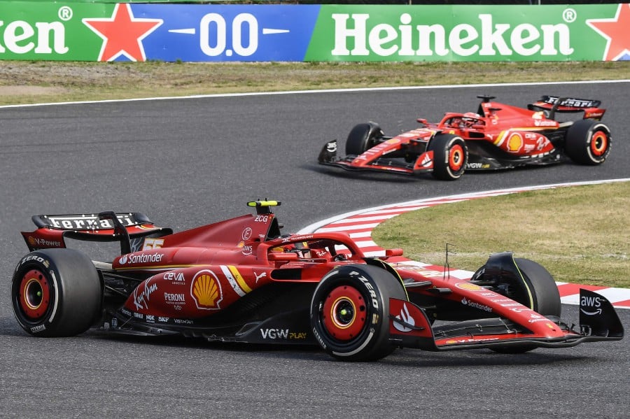 Ferrari's Spanish driver Carlos Sainz Jr (bottom) and Ferrari's Monegasque driver Charles Leclerc (top) take a turn during the Formula One Japanese Grand Prix race at the Suzuka circuit in Suzuka, Mie. - AFP PIC