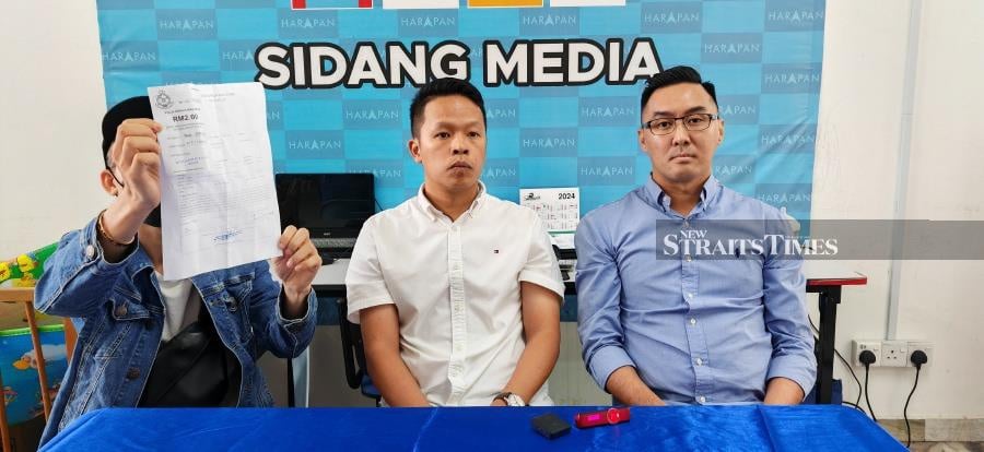 Wong (left) showing the police report on his missing sister with Semambu assemblyman Chan Chun Kuang (middle) and Malaysia International Humanitarian Organisation public relations officer Daniel Khoo (left) at Chan’s service centre in Kuantan. - NSTP/Asrol Awang