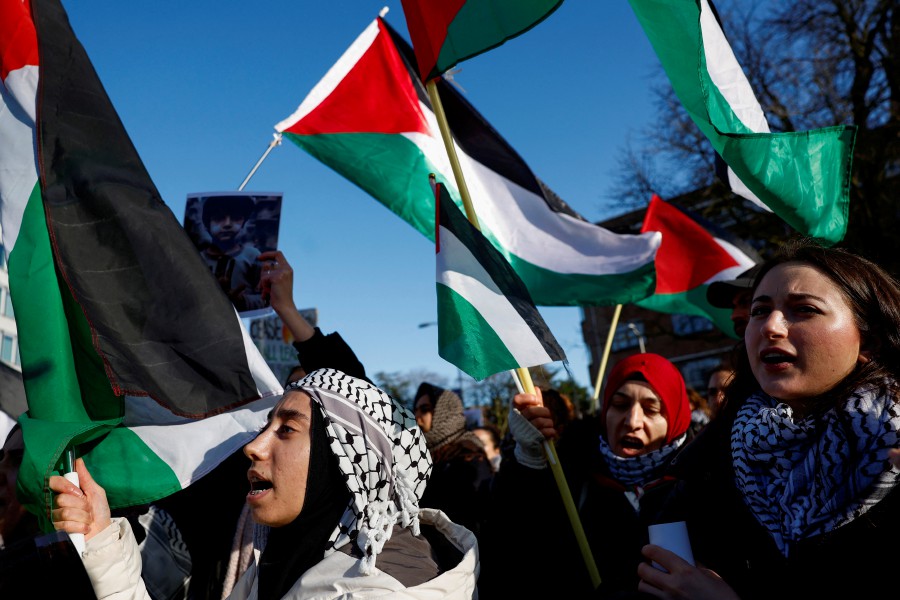 People hold flags during a pro-Palestinian demonstration outside the International Court of Justice (ICJ) as judges rule on emergency measures against Israel following accusations by South Africa that the Israeli military operation in Gaza is a state-led genocide, in The Hague, Netherlands. - REUTERS PIC
