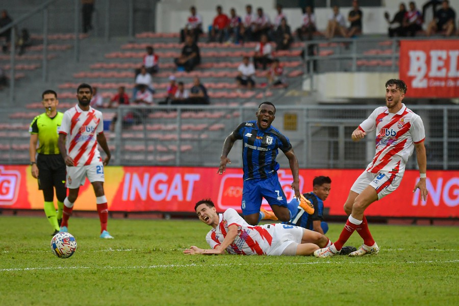 Kuching City’s Tchetche Hermann (centre) is tackled by Kuala Lumpur’s Ryan Edward (centre) during the match at KLFA stadium. - BERNAMA PIC