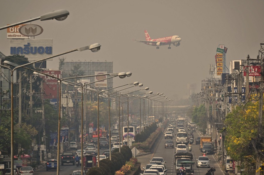  An Air Asia plane descends towards Chiang Mai International Airport amid high levels of air pollution in Chiang Mai on April 10, 2023. - AFP PIC