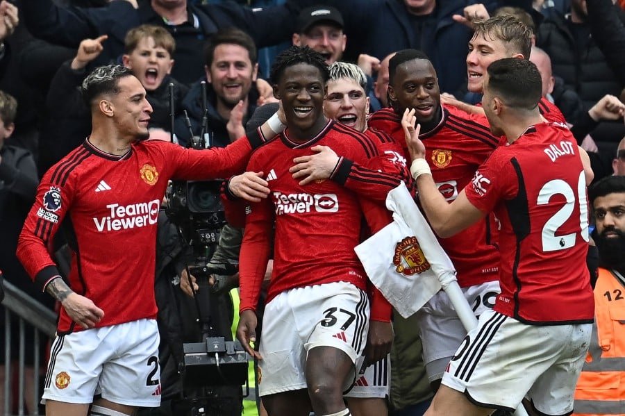 Manchester United's Kobbie Mainoo (C) celebrates with teammates after scoring their second goal against Liverpool at Old Trafford in Manchester. - AFP PIC