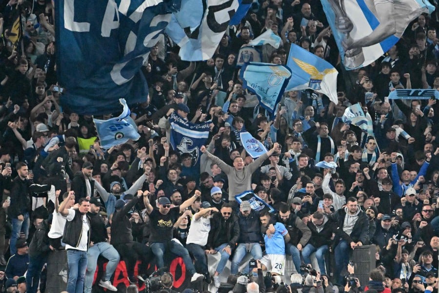 Lazio's Italian midfielder Mattia Zaccagni (bottom C-R) joins Lazio fans in a tribune to celebrate at the end of the match against AS Roma on March 19, 2023 at the Olympic stadium in Rome. - AFP PIC