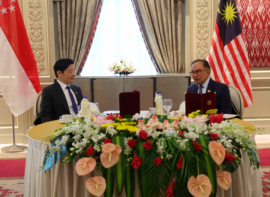 Prime Minister Datuk Seri Anwar Ibrahim (right) speaks to his Singapore counterpart Lawrence Wong in Putrajaya. - BERNAMA PIC