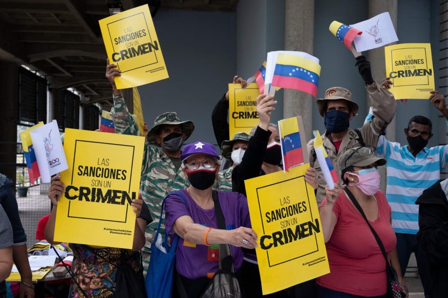 Supporters of the Venezuelan government demonstrate against the economic sanctions imposed by the United States as they prepare to participate in a march to mark International Workers' Day, in Caracas. - AFP pic