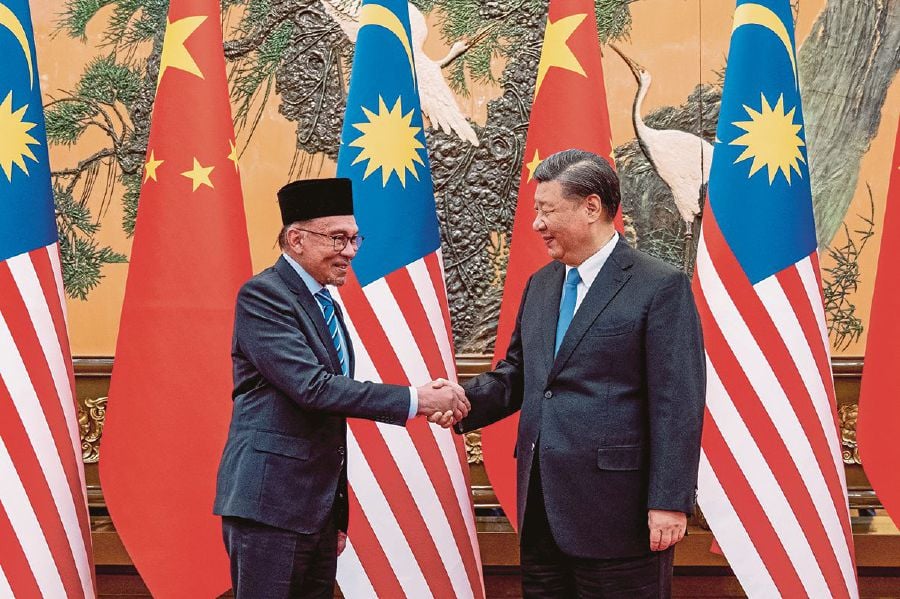 A file pic dated March 31, 2023, shows Chinese President Xi Jinping welcoming Malaysian Prime Minister Datuk Seri Anwar Ibrahim at the Great Hall of the People, in Beijing. s