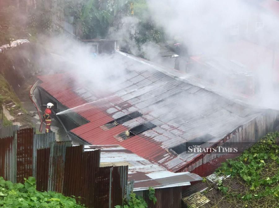 A fireman seen putting out the fire at a house in Brinchang. - Pix courtesy of Fire and Rescue Dept 