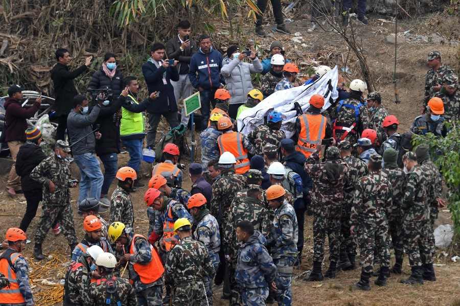  Rescuers carry the body of a victim who died in a Yeti Airlines plane crash in Pokhara. - AFP PIC