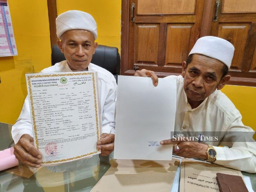 Abdul Rahman Yusof (left) and Wan Yusoff Wan Hassan showing the marriage certificate issued by the Narathiwat Islamic Religious Council to Malaysian couples. - NSTP/Sharifah Mahsinah Abdullah