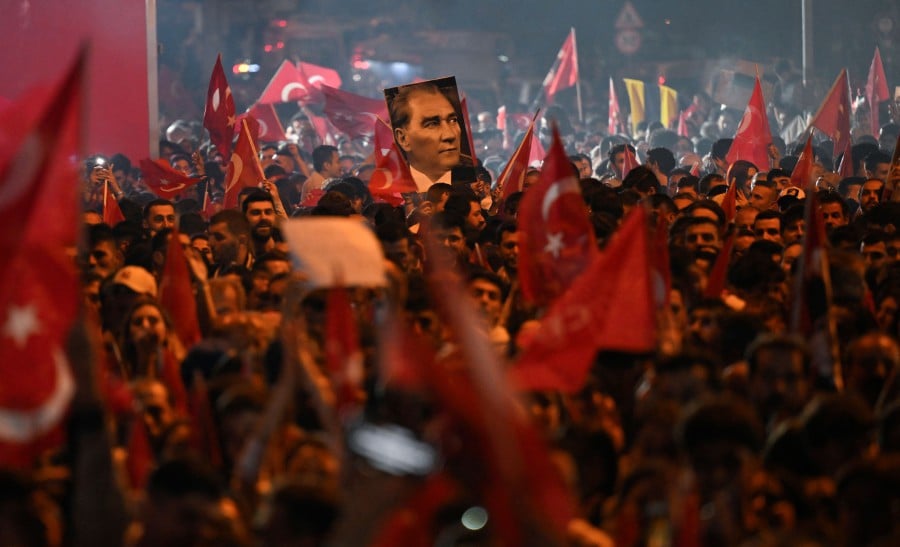 Opposition Republican People's Party (CHP) supporters celebrate outside the main municipality building following municipal elections across Turkiye, in Istanbul. -AFP/YASIN AKGUL