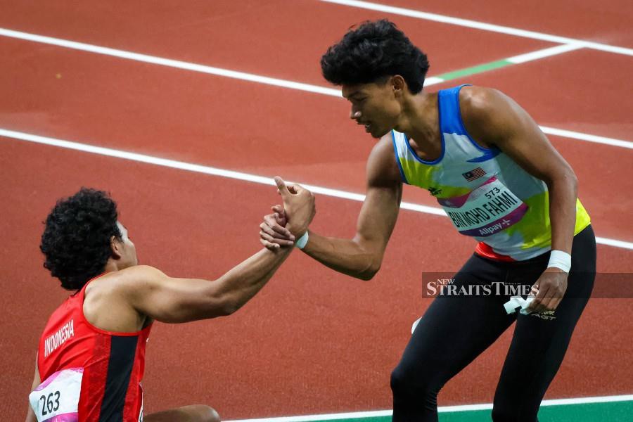 Malaysian speedster Azeem Fahmi (right) after the Asian Games men's 100m final. -NSTP/ASYRAF HAMZAH