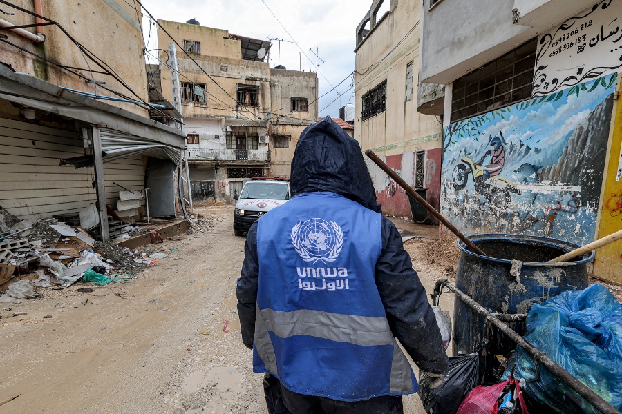 A man collects trash while wearing a jacket bearing the logo of the United Nations Relief and Works Agency for Palestine Refugees in the Near East (UNRWA), along a street in the city of Jenin in the occupied West Bank on January 30, 2024. A Norwegian Labour MP Asmund Aukrust told the Dagbladet newspaper he had nominated the UN Relief and Works Agency “for its long-term work to provide vital support to Palestine and the region in general”. -AFP/Jaafar ASHTIYEH