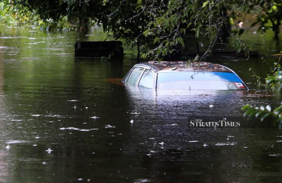 A submerged car was spotted near Lanchang. In numerous low-lying villages in Kelantan, floodwaters reached up to 1.5 metres deep. -NSTP/NIK ABDULLAH NIK OMAR