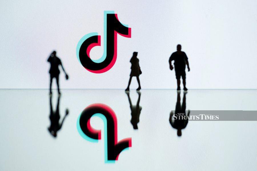 (FILE PHOTO) This photograph taken in Mulhouse, eastern France shows figurines next to the logo of the social media video sharing app TikTok reflected in mirrors. -AFP/SEBASTIEN BOZON