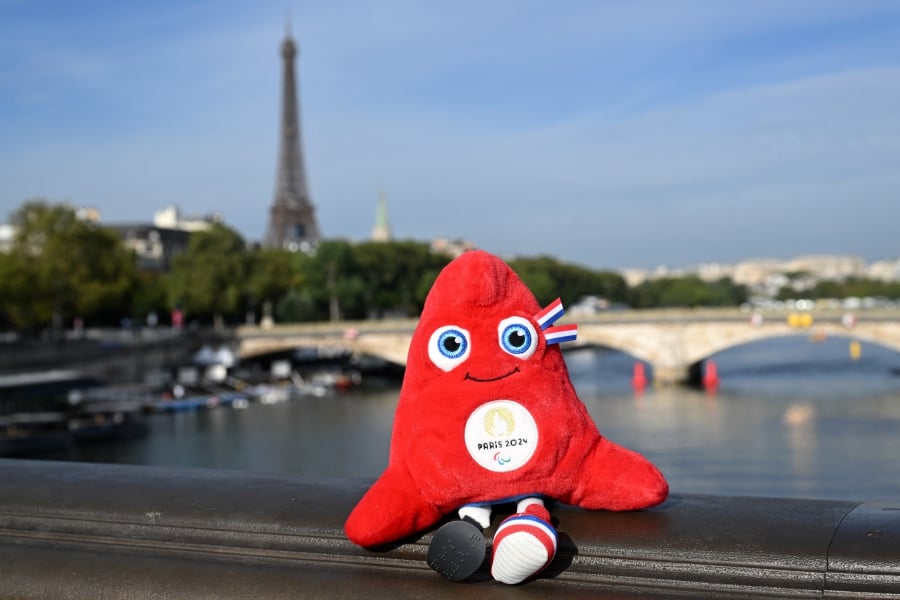 The Paris 2024 Olympics mascot, the Phrygian cap, symbol of revolutions, the French Republic and freedom, is placed on the railings of the Alexander III Bridge that crosses the River Seine. -AFP/Bertrand GUAY
