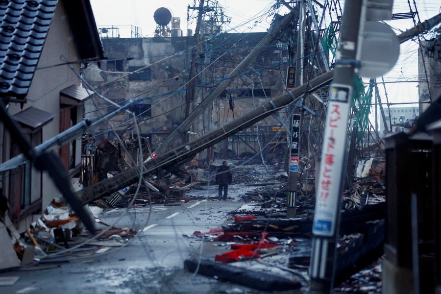 A man makes his way along Asaichi-dori street, which burned down due to a fire following an earthquake, in Wajima, Japan, January 4, 2024. -REUTERS/Kim Kyung-Hoon